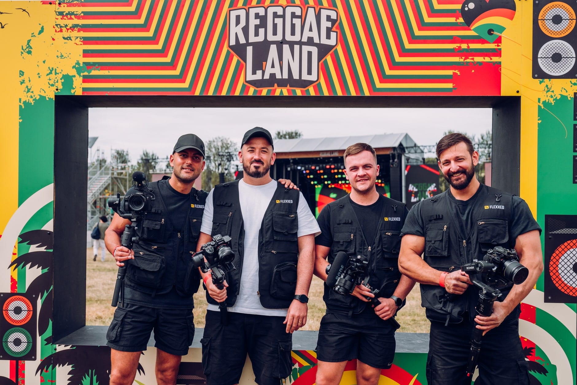 The four-person Flexxed crew with cameras and gimbals under the Reggae Land arch