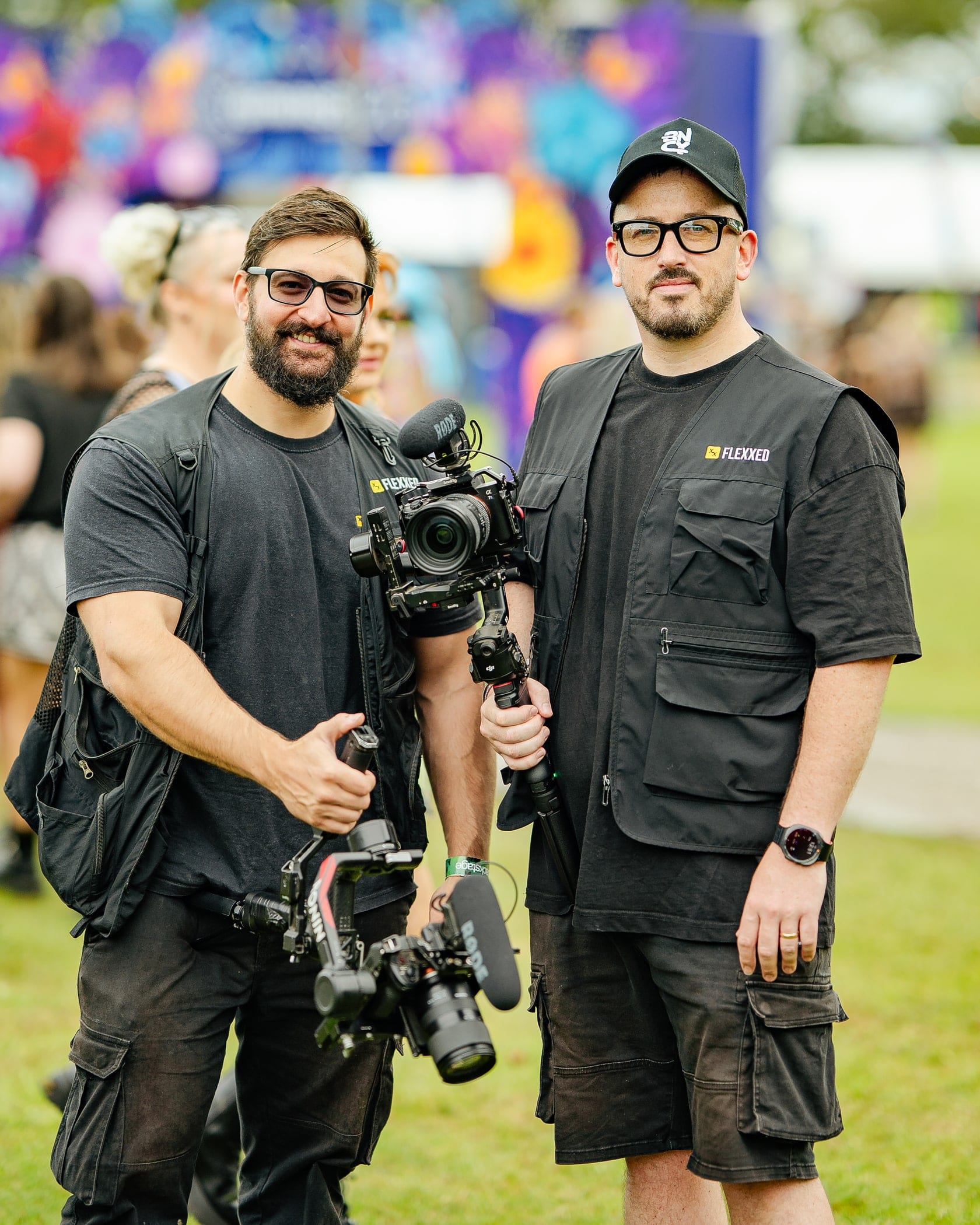 Two camera operators in Flexxed vests with a rig on a festival site