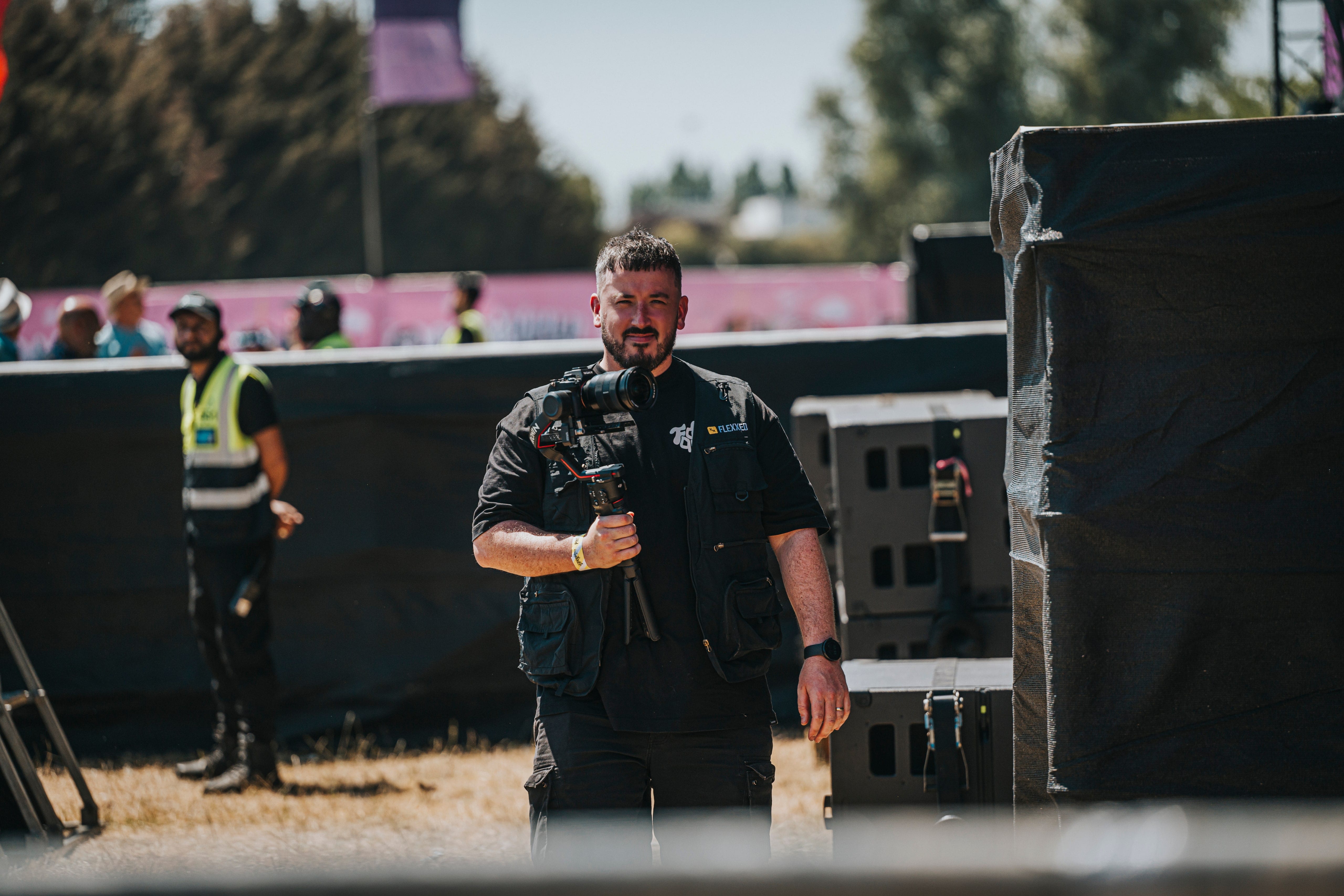 A Flexxed camera operator walking the Boogietown festival site with a camera rig