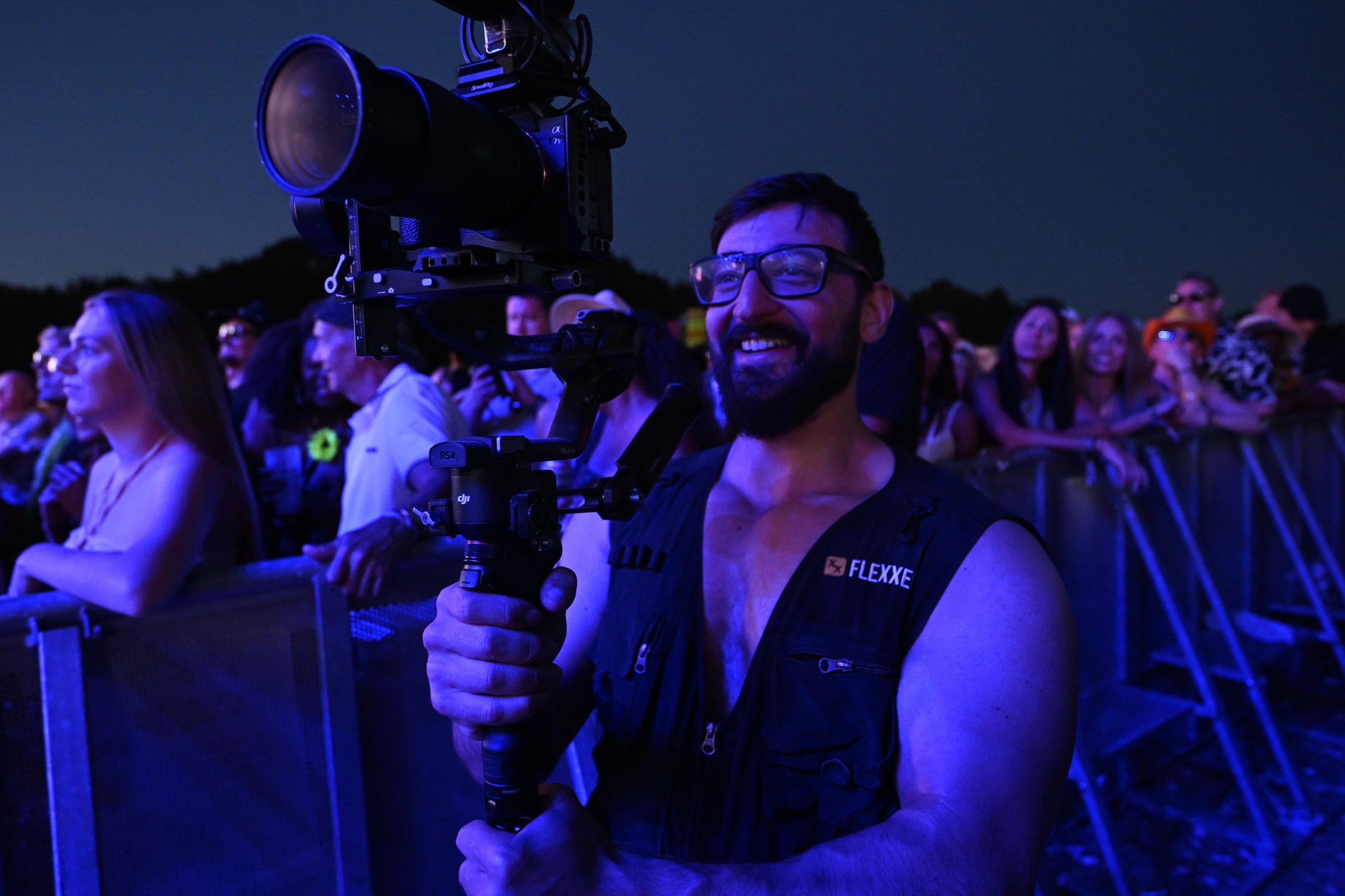 A Flexxed operator at the Boogietown front barrier at dusk, gimbal raised over the crowd