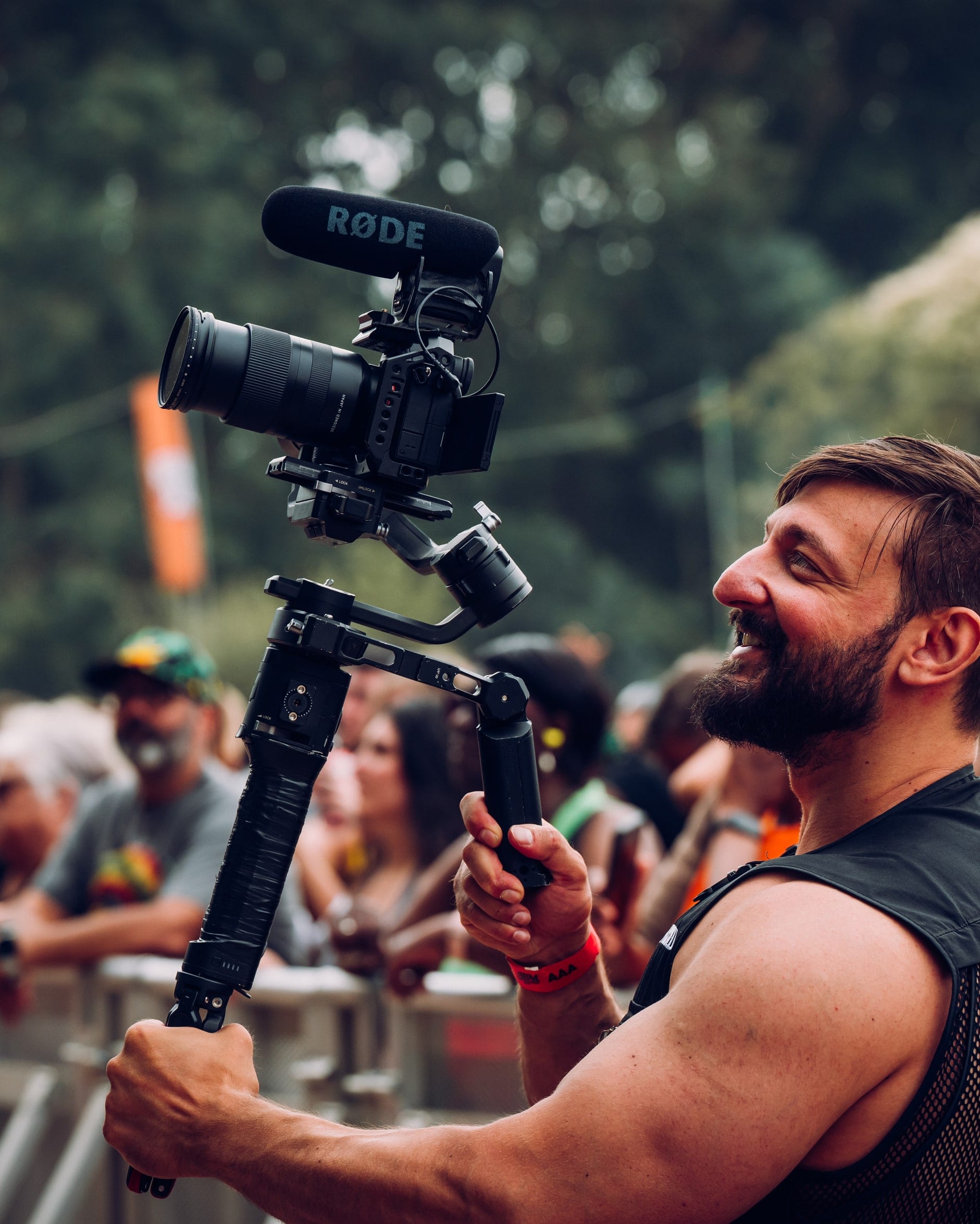 Flexxed camera operator filming a festival crowd from the front barrier with a gimbal