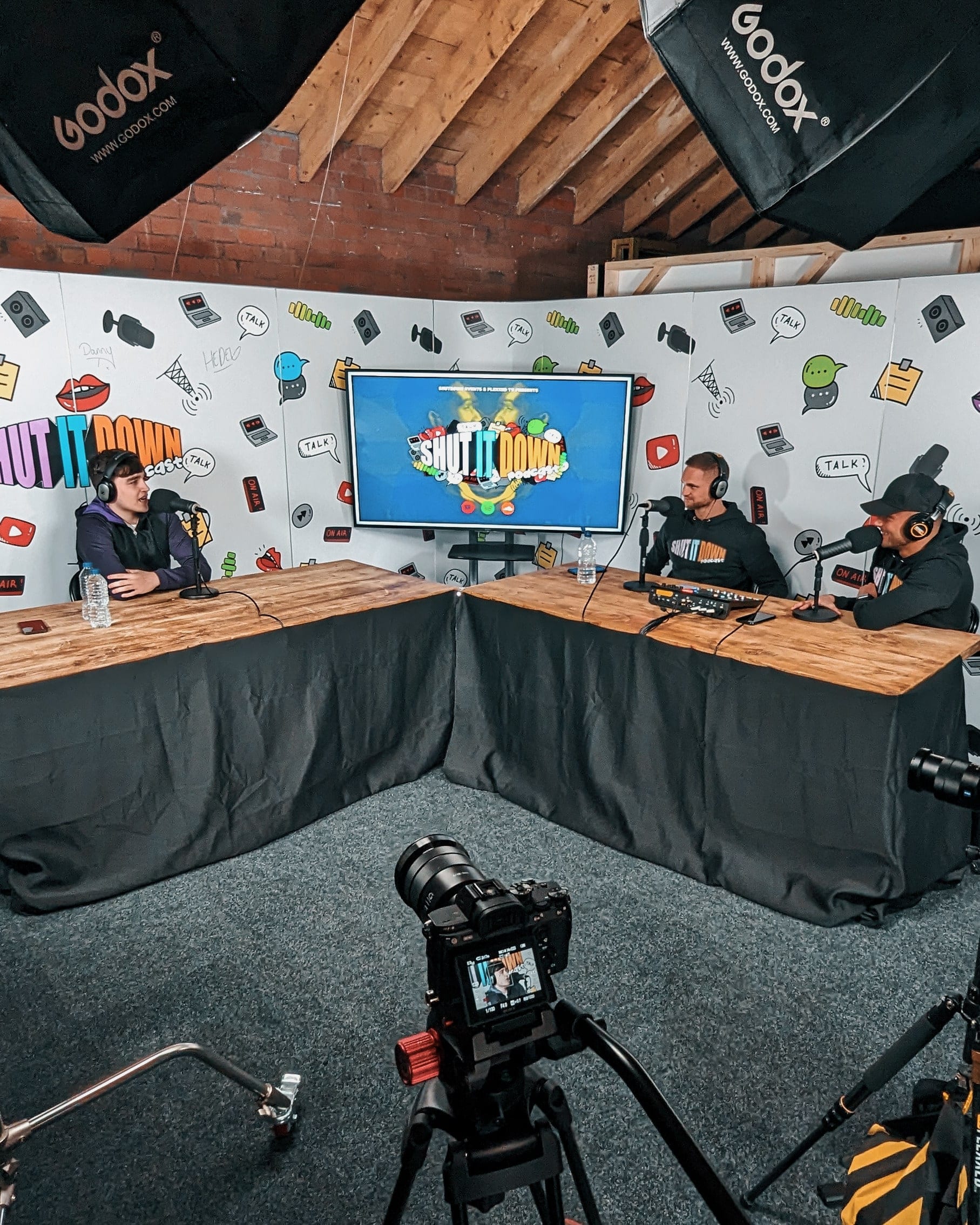 The Flexxed podcast set with three presenters at the desk, softboxes and three cameras in position