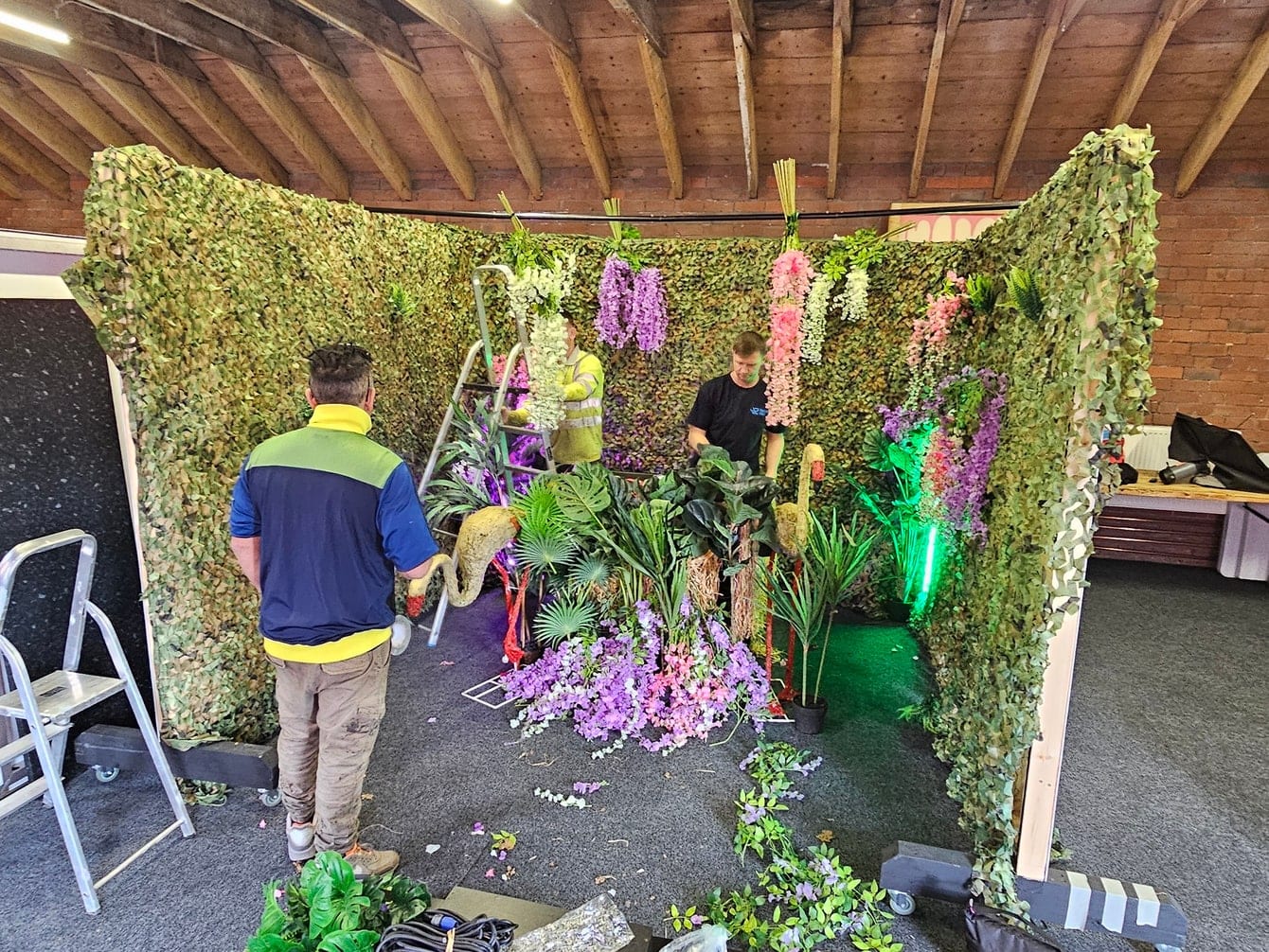 A foliage and flower set being built in the studio under the beamed ceiling