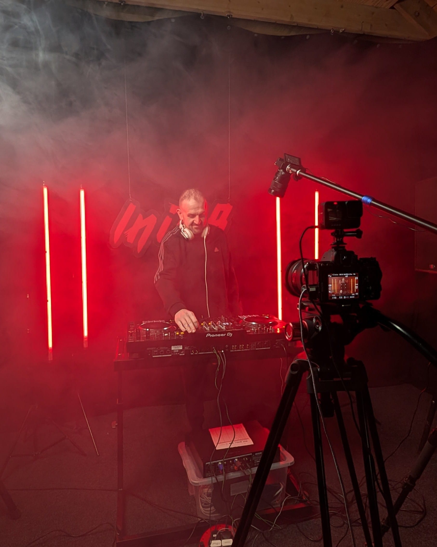 Performer at the decks in red light and haze, camera on a tripod in the foreground