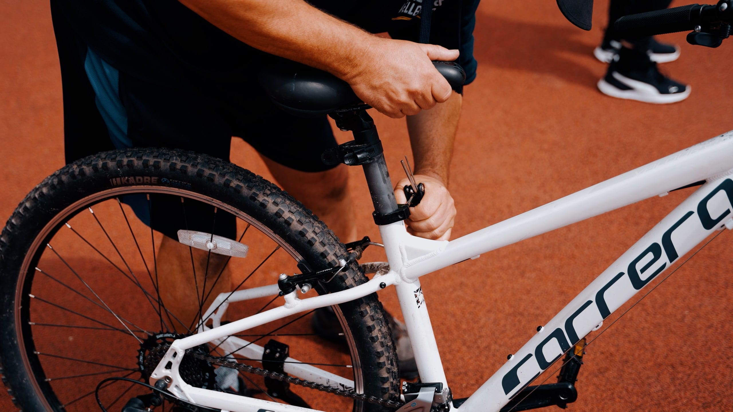 A road bike photographed low and close, a rider clipping in behind